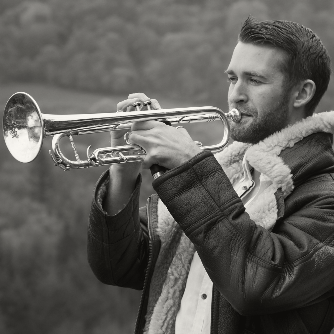 Mark Perry playing trumpet with hilly backdrop