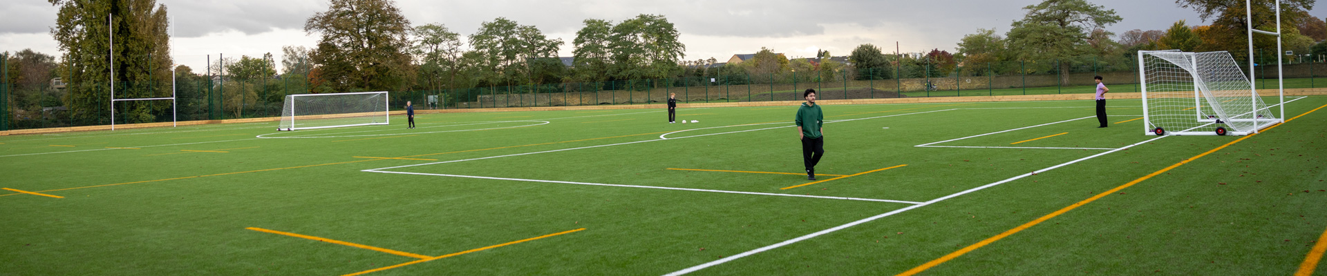 5g all-weather sports field with students playing football