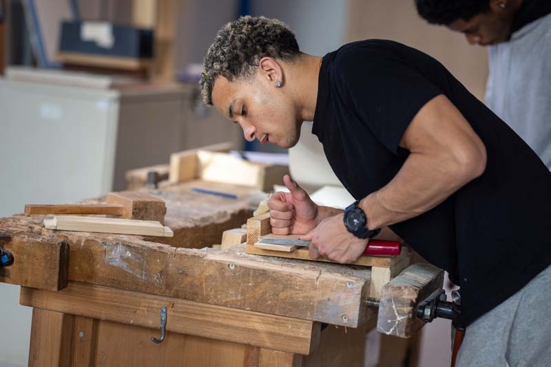 construction male student filing wood