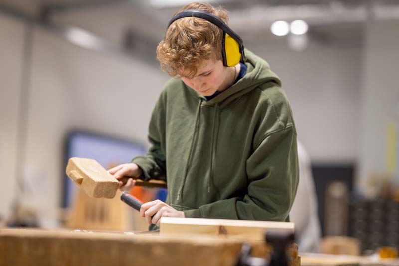 construction male student using mallet