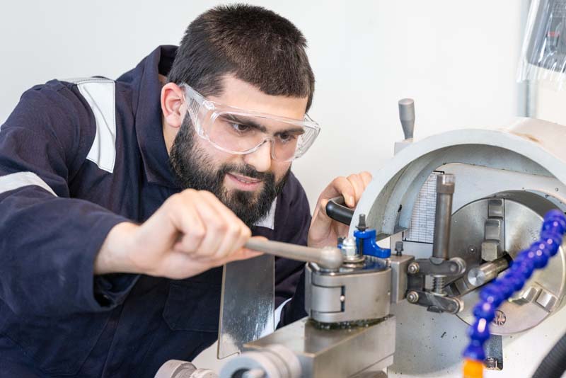 Engineering male student adjusting a machine