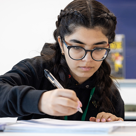 female student writing notes in class