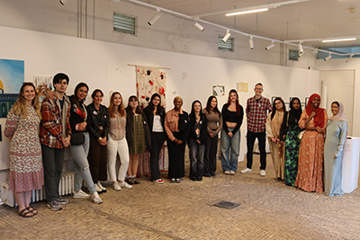 students and teachers posing at the end-of-year art exhibition
