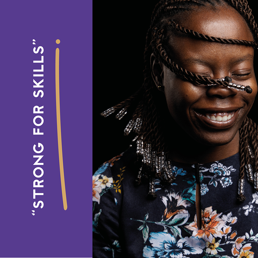 Strong for Skills - Orowo is one of our Be Extraordinary students - swinging her braids across her face, eyes closed and smiling and wearing a flowery top.